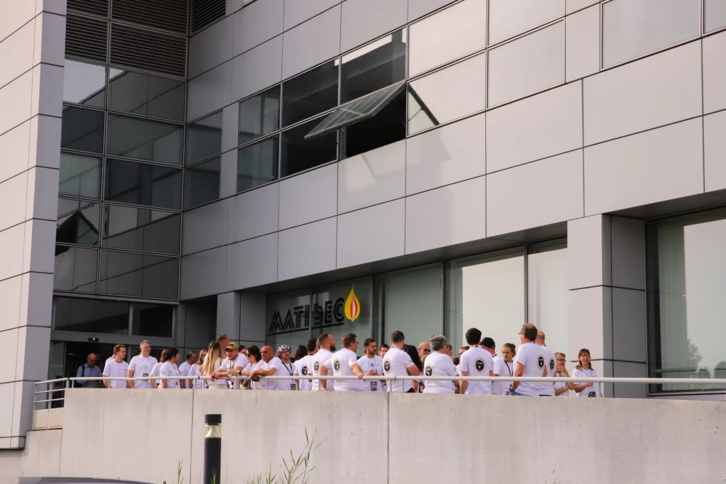 La photo montre tous les salariés de MATISEC à l'entrée des locaux de l'entreprise tous vêtus du tee-shirt MATISEC blanc